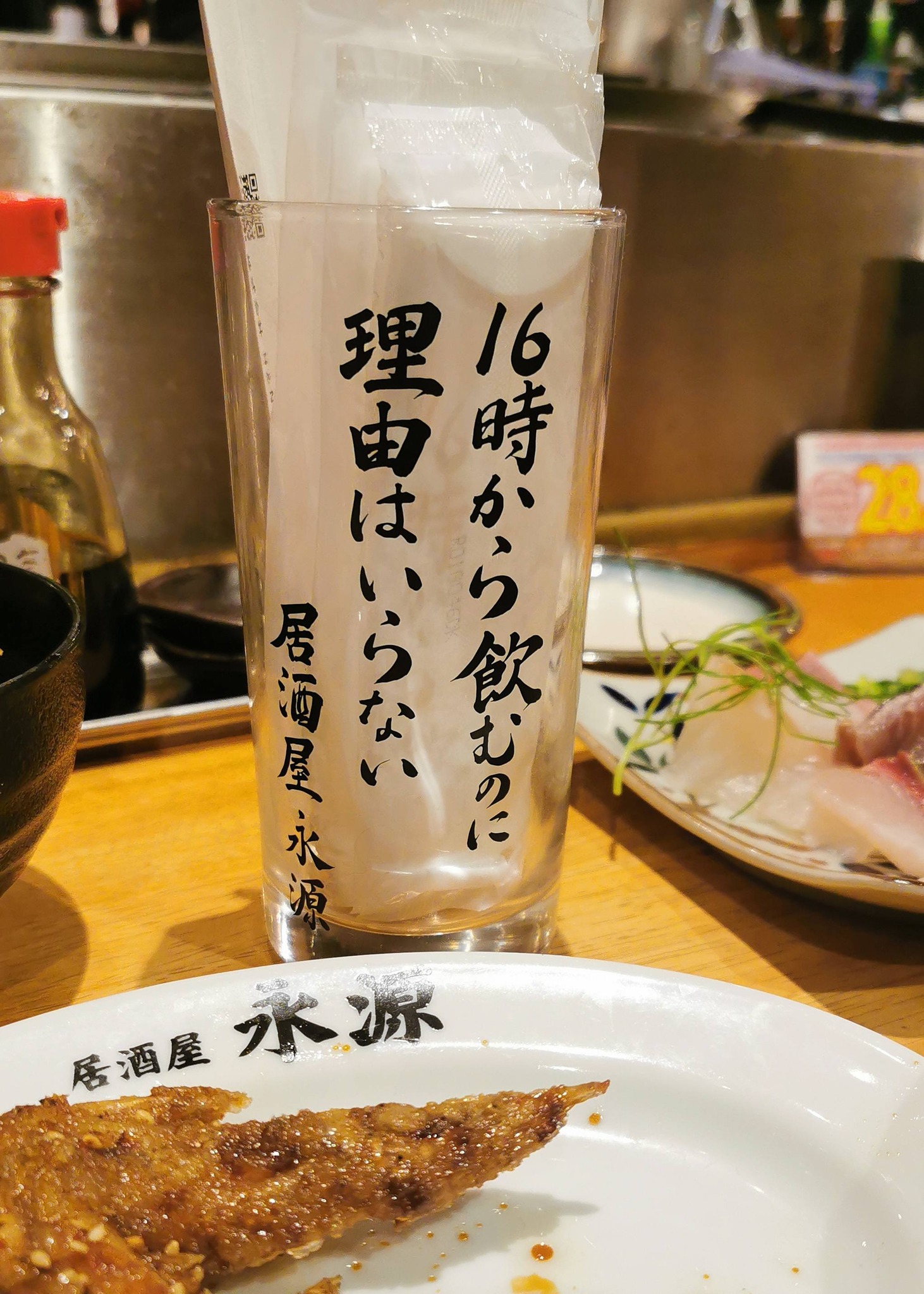 居酒屋の卓上に置かれたグラスと料理
